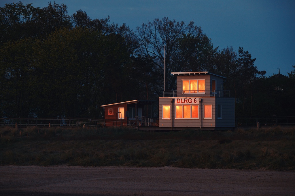 In den Fenstern der DLRG Wache am Strandaufgang 6 in der Boltenhagener Bucht an der Ostsee spiegelt sich der Sonnenaufgang CS-240427-0870-2.jpg